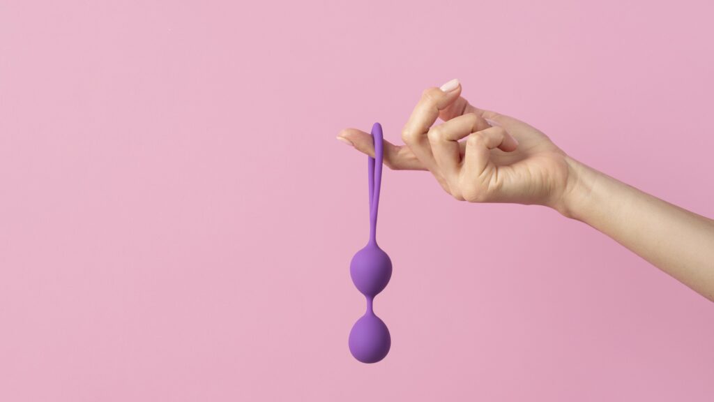 มือกำลังถือ kegel ball สำหรับการบริหารอุ้งเชิงกรานและฝึกกล้ามเนื้ออุ้งเชิงกราน